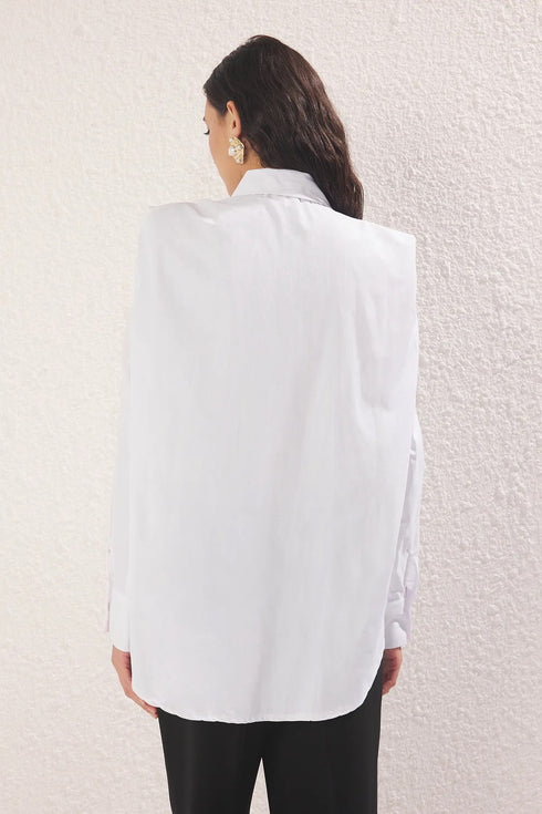 قميص أبيض بتفاصيل من اللؤلؤ