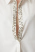 قميص أبيض بتفاصيل اللؤلؤ