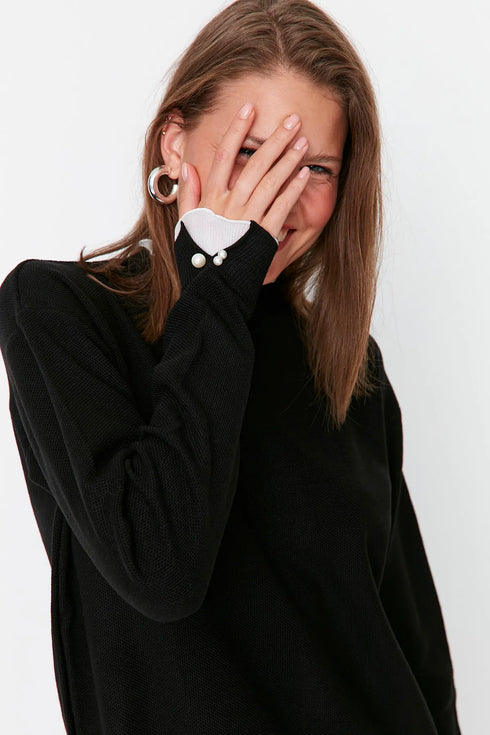 كنزة تريكو باللون الأسود وتفاصيل لؤلؤ